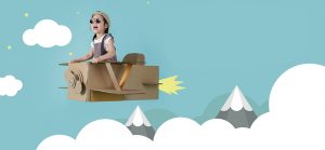 Asian little child girl playing with cardboard toy airplane handicraft over the clouds on blue sky long banner with copy space for your text, Creative with family and dreaming of flying concept